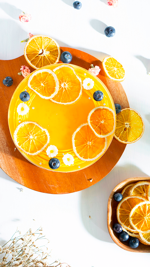 Tarte au citron décorée de tranches d'oranges.